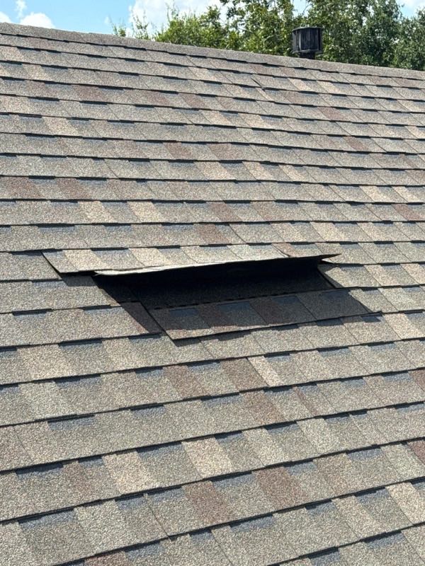 Shingle course lifted and folded back by wind