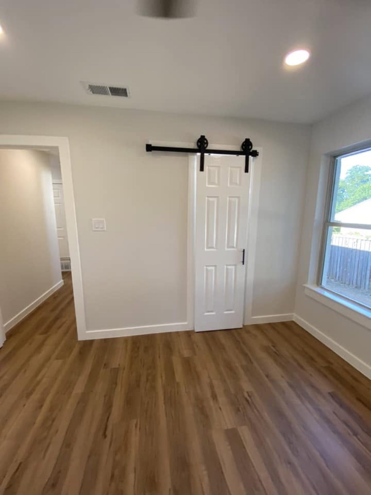 Barn door on a black rail over new plank floor