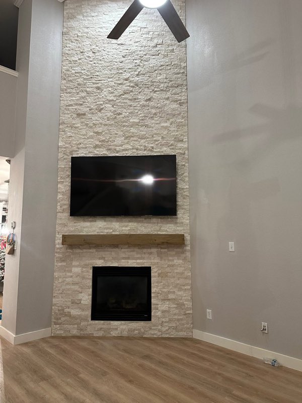 Stacked stone fireplace with wood mantel